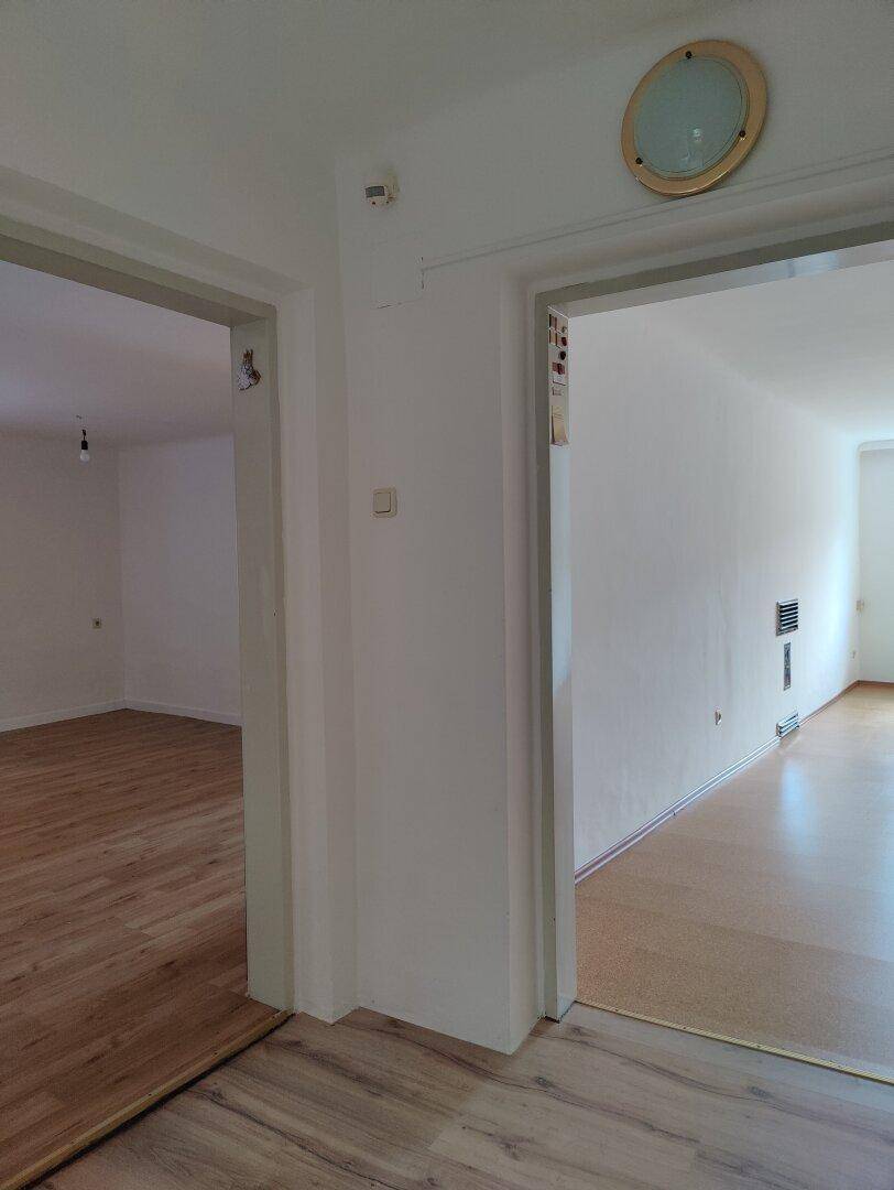 Heller Flur mit Laminatboden und Zugängen zu angrenzenden Räumen.