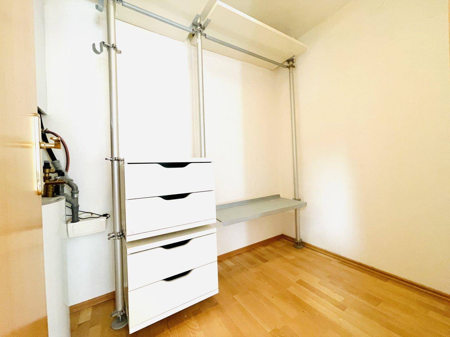 Praktischer Abstellraum mit Regalsystem, Schubladen und Holzboden.
