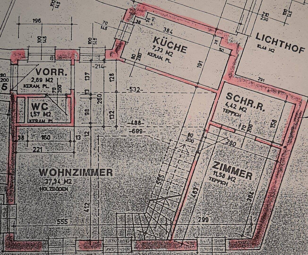 Grundrissplan zeigt Wohnzimmer, Küche, WC und weitere Zimmer mit verschiedenen Bodenbelägen.