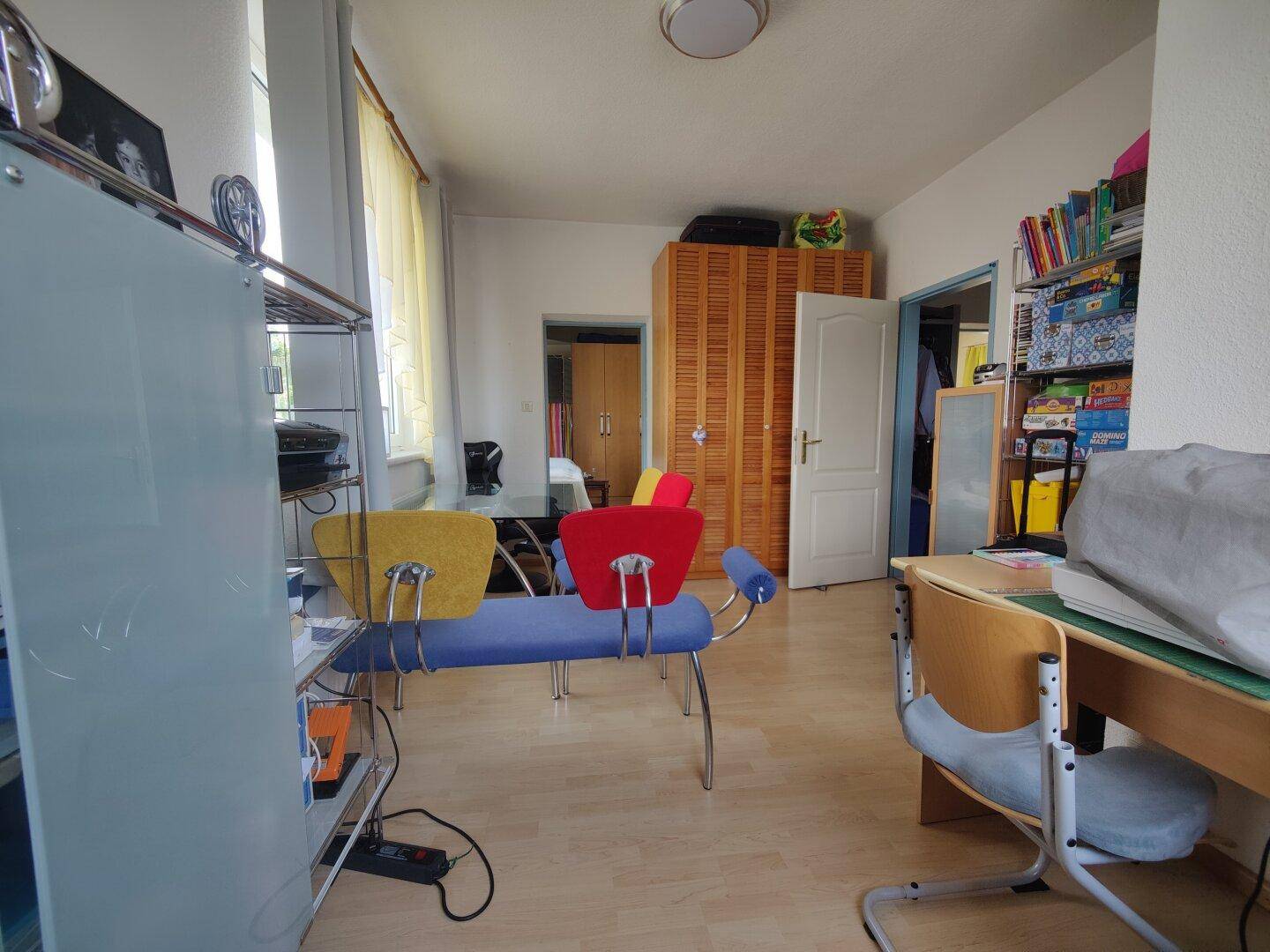 Vielseitiger Raum, eingerichtet als Büro oder Kinderzimmer, mit hellem Holzboden.