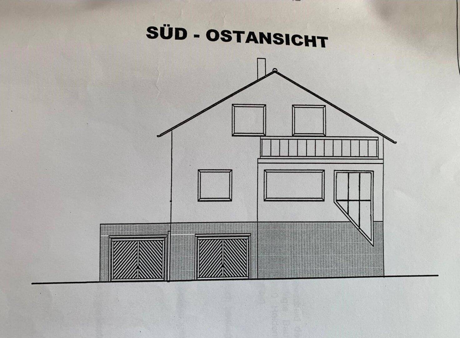 Süd-Ostansicht des Hauses mit Balkon und Garagen im Erdgeschoss.