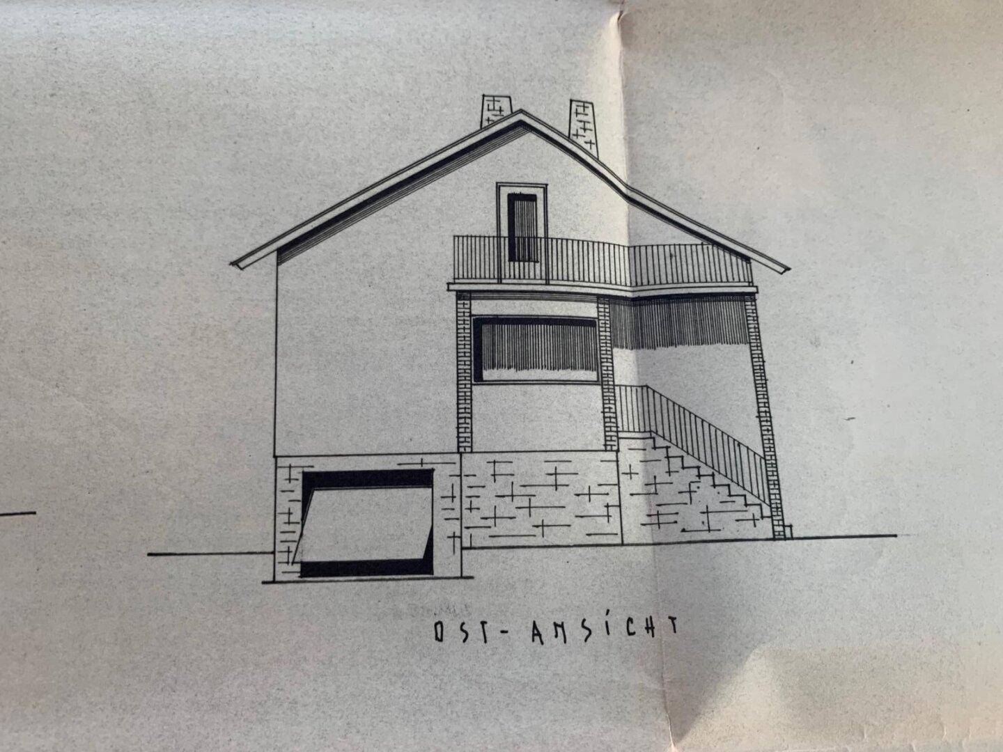 Ostansicht des Hauses mit Garage, Balkon und Außentreppe.