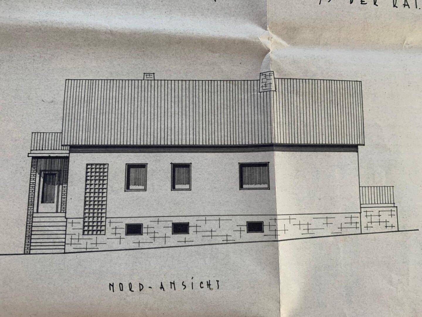 Nordansicht des Hauses mit Balkon und Kellerfenstern.
