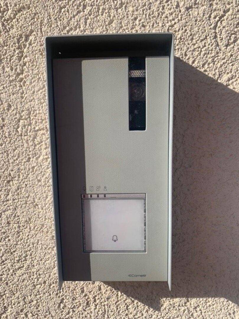 Moderne Gegensprechanlage mit Kamera an der strukturierten Hauswand.