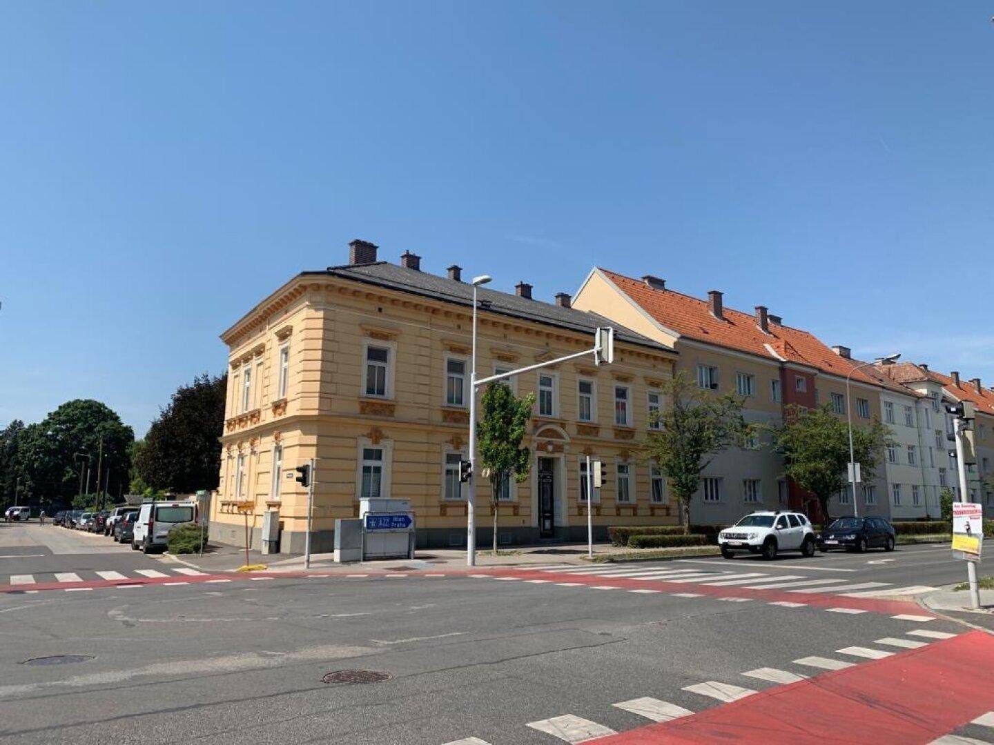 Eckansicht des historischen Gebäudes an einer Straßenkreuzung mit Blick auf die umliegende Stadtbebauung.