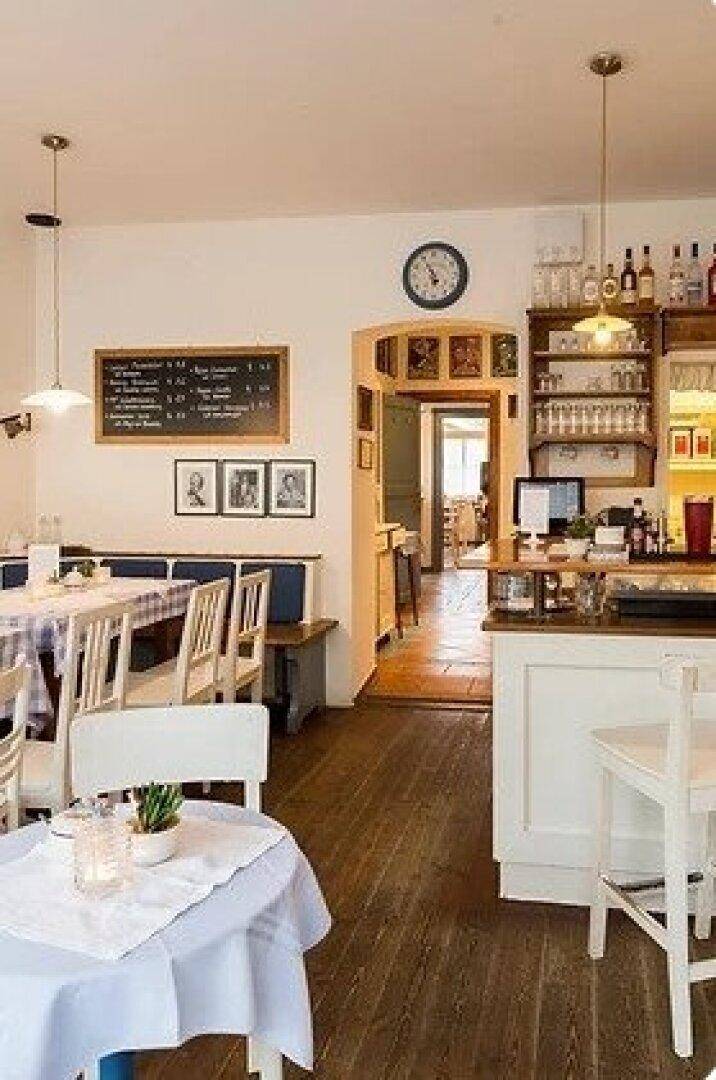 Gastraum mit Holzboden, Theke und Blick in einen weiteren Bereich des Restaurants.