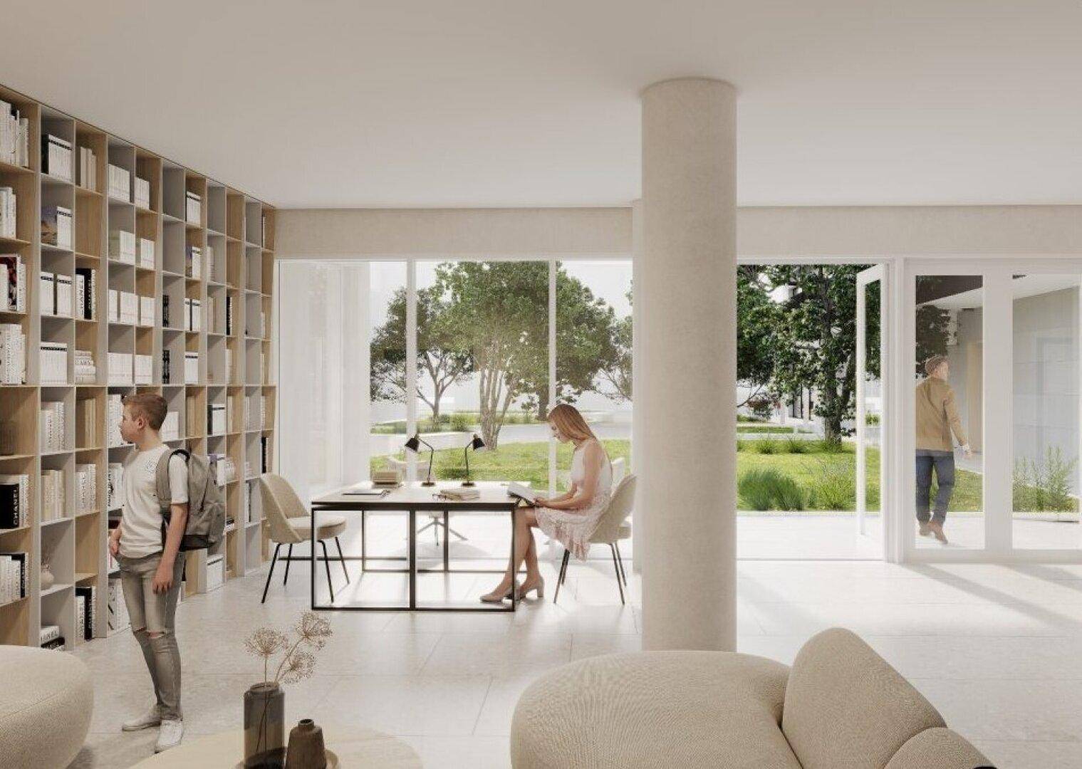 Heller Bibliotheks- und Loungebereich mit großen Fenstern, Blick ins Grüne und Bücherregalen.