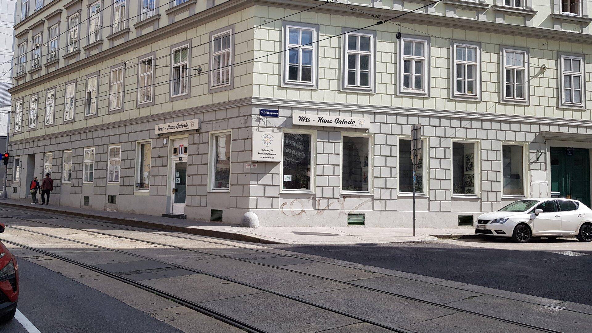 Historisches Eckgebäude in der Stadt mit Geschäften im Erdgeschoss und Wohnungen darüber.