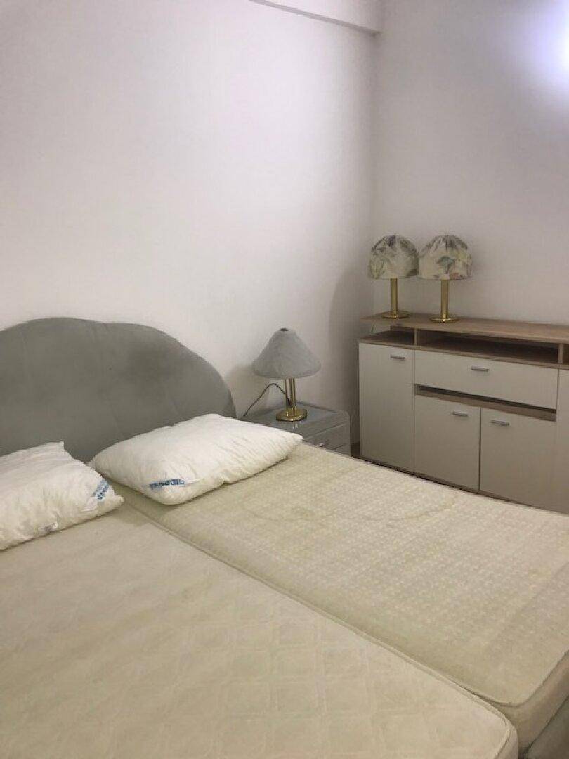 Schlafzimmer mit Bett, zwei Nachttischlampen und einer Kommode.