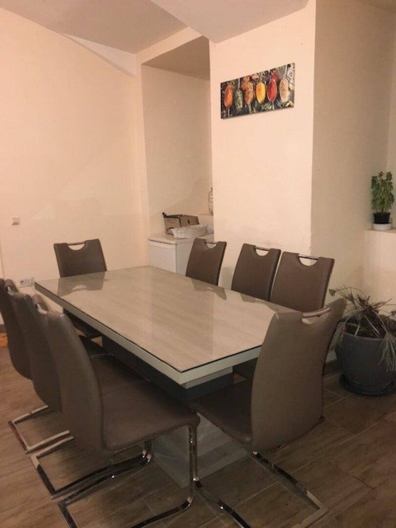 Esszimmer mit großem Esstisch und modernen Stühlen.