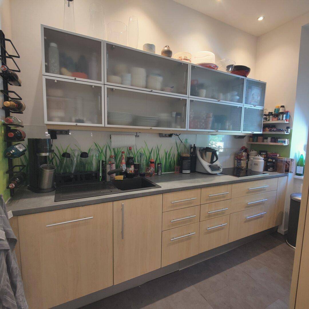 Funktionale Küche mit Holzfronten, integrierten Geräten und praktischem Stauraum.