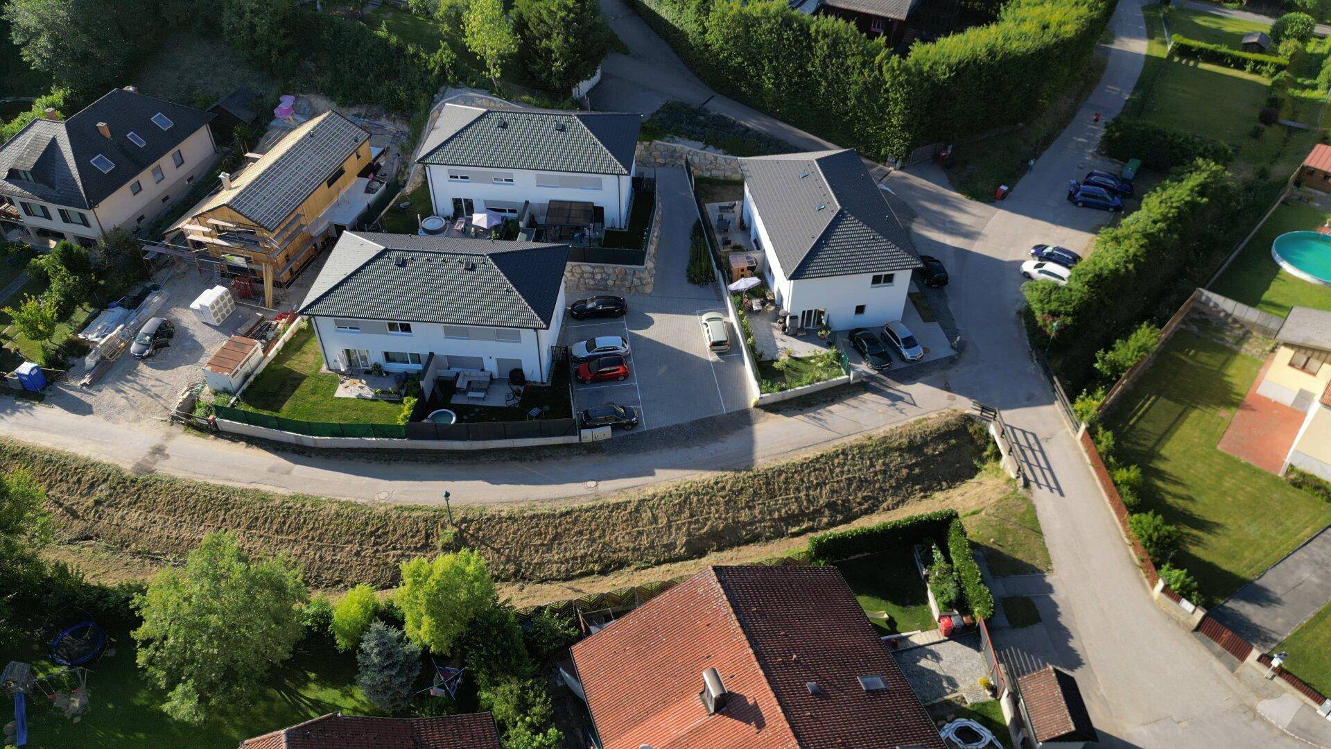 Panoramablick aus der Vogelperspektive auf eine Wohngegend mit Einfamilienhäusern und viel Grün.