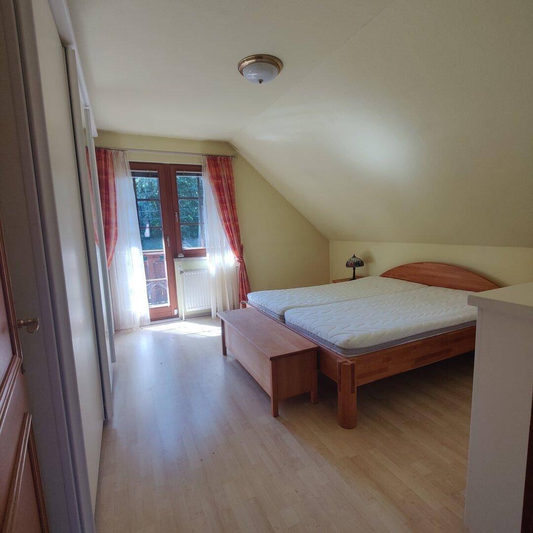 Gemütliches Schlafzimmer mit Doppelbett, Kleiderschrank und Zugang zum Balkon.