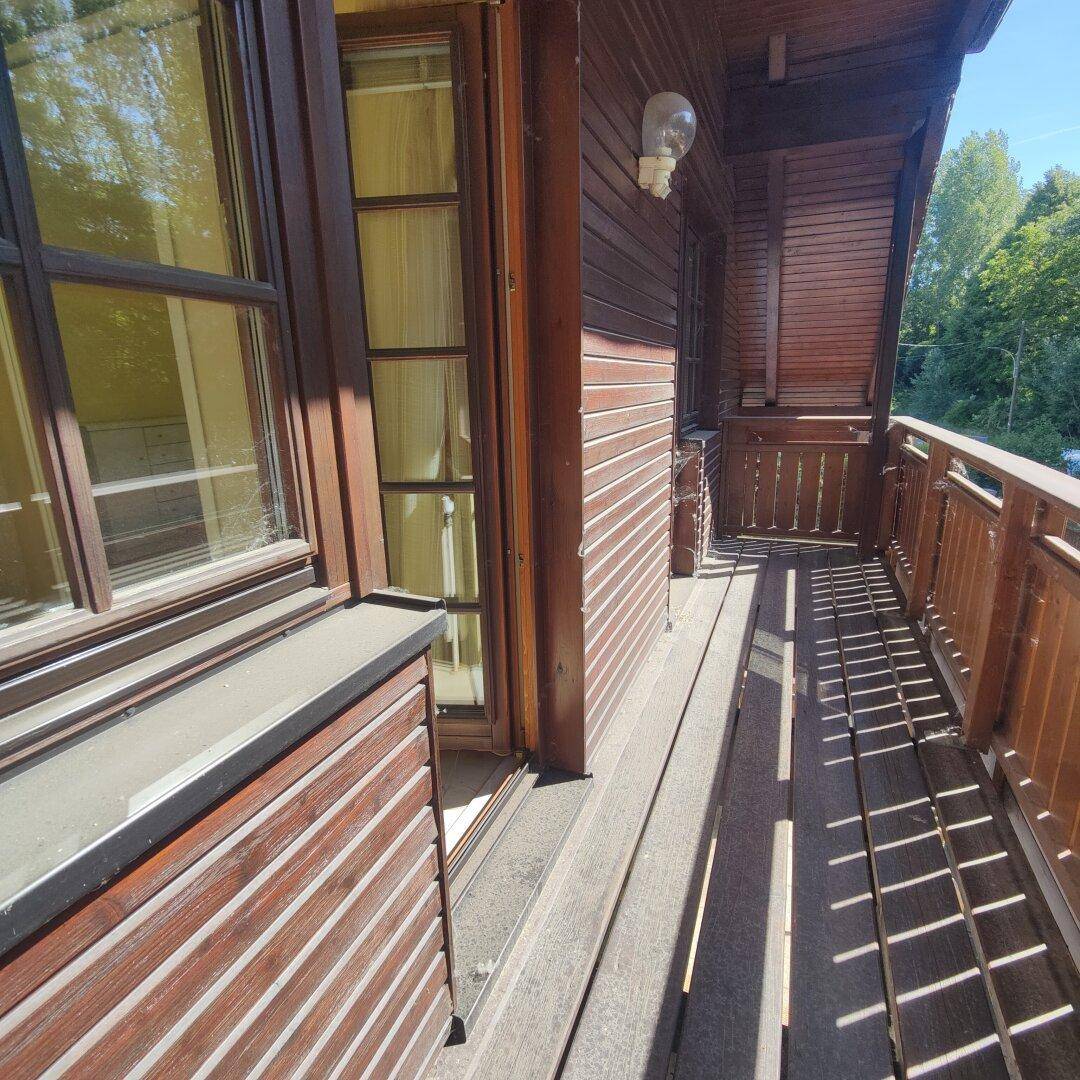 Langer Balkon mit Holzgeländer und Holzboden, ideal zum Entspannen im Freien.