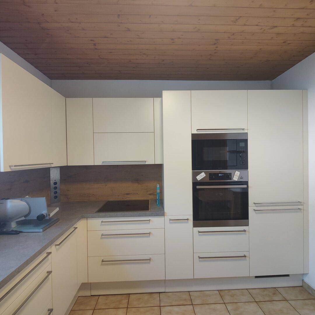 Detailansicht der modernen Küche mit integriertem Backofen, Mikrowelle und Induktionskochfeld.