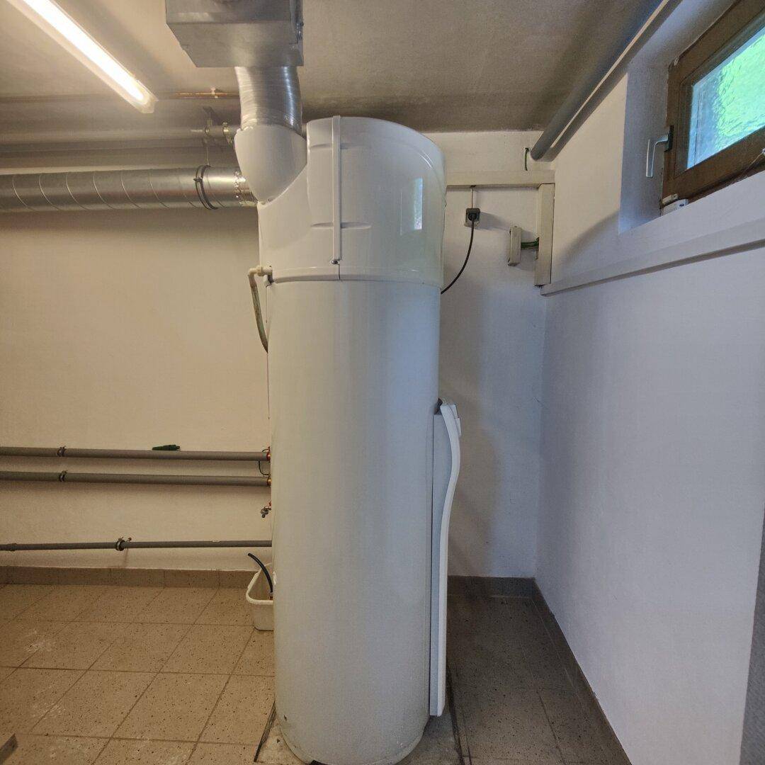 Kellerraum mit großem Warmwasserspeicher und sichtbaren Installationen.