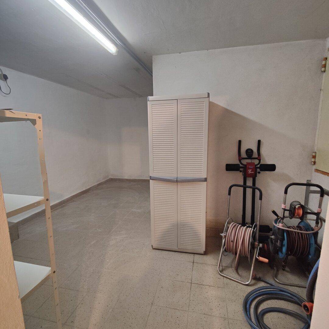 Kellerraum mit Fliesenboden, Regalen und Fitnessgeräten, ideal für Lagerung und Hobby.