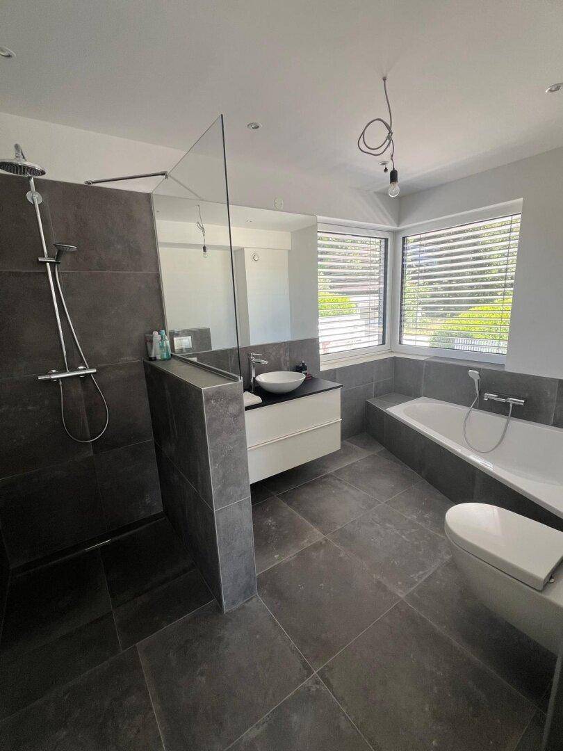 Modernes Badezimmer mit großer begehbarer Dusche, Badewanne und Doppelwaschbecken.
