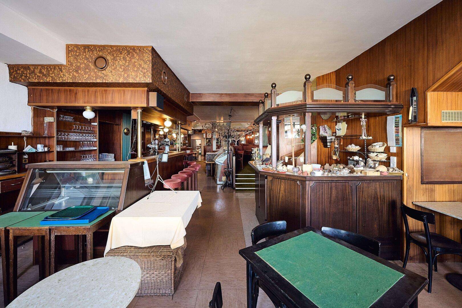 Ein weiterer Bereich des Restaurants mit Theken, Vitrinen und Tischen für Gäste.