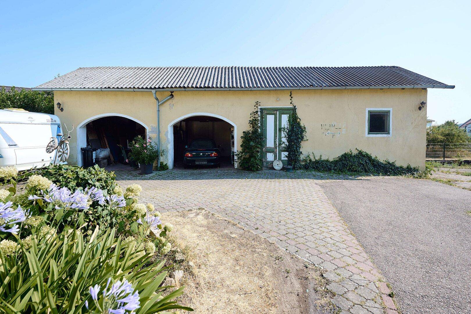 Freistehende Garage mit zwei Stellplätzen und gepflasterter Zufahrt.