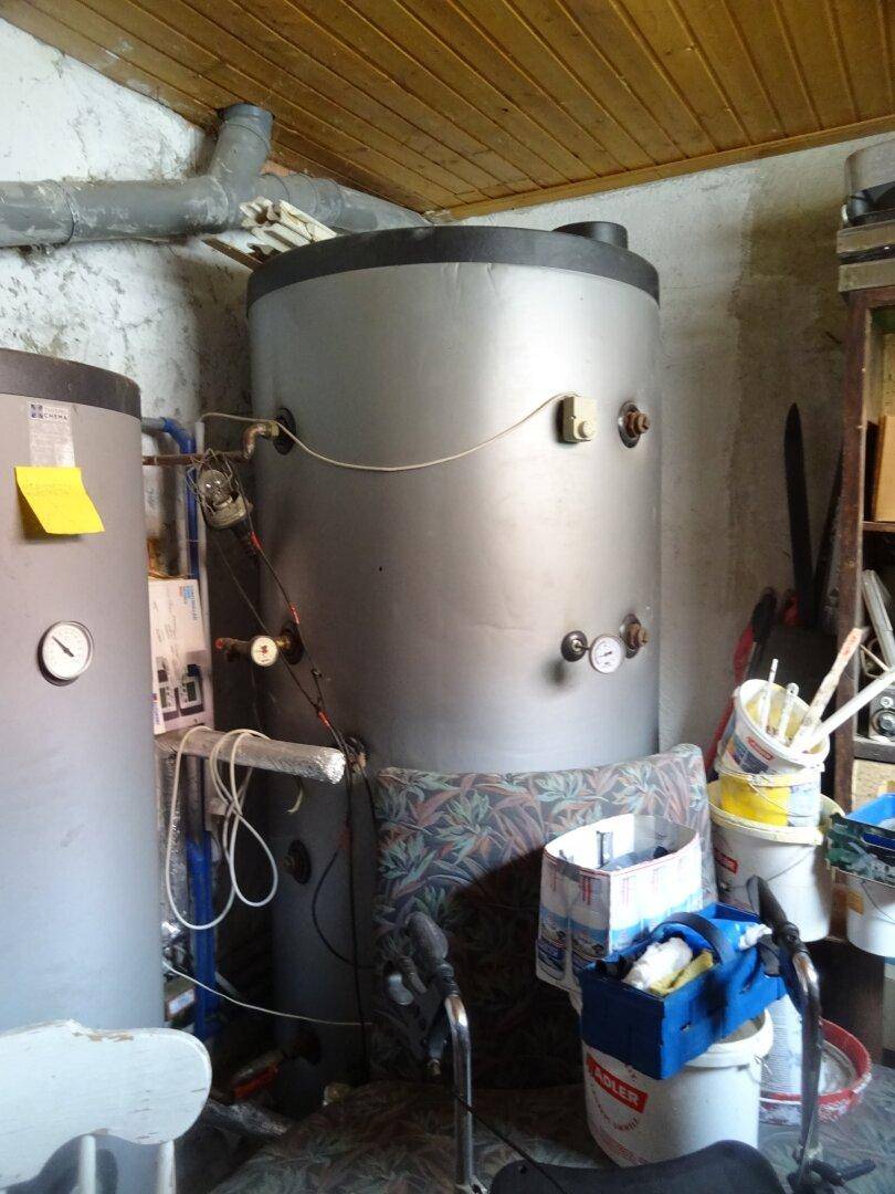 Technikraum mit Warmwasserspeicher und verschiedenen Installationen.