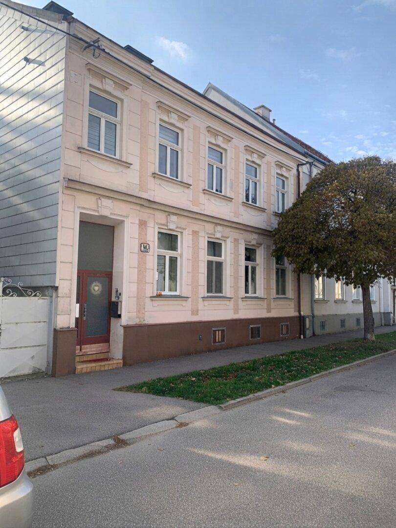 Ansicht des Mehrfamilienhauses von der Straßenseite mit klassischer Architektur und hohen Fenstern.