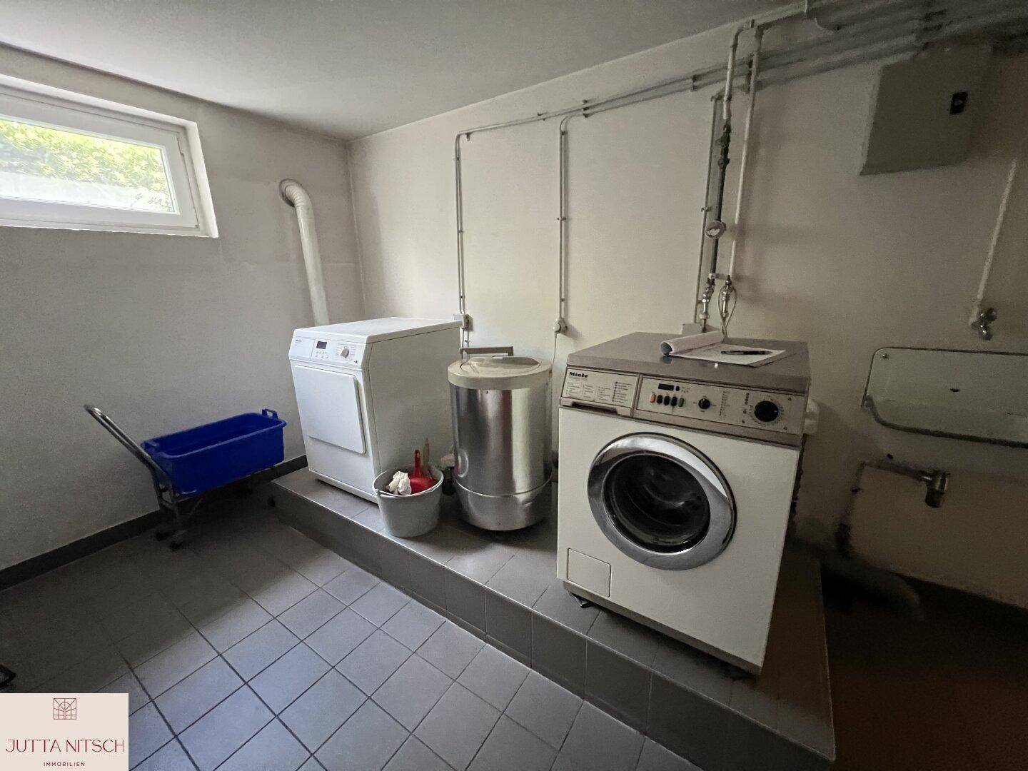 Gemeinschaftlicher Waschraum im Keller mit Waschmaschinen und Trockner.