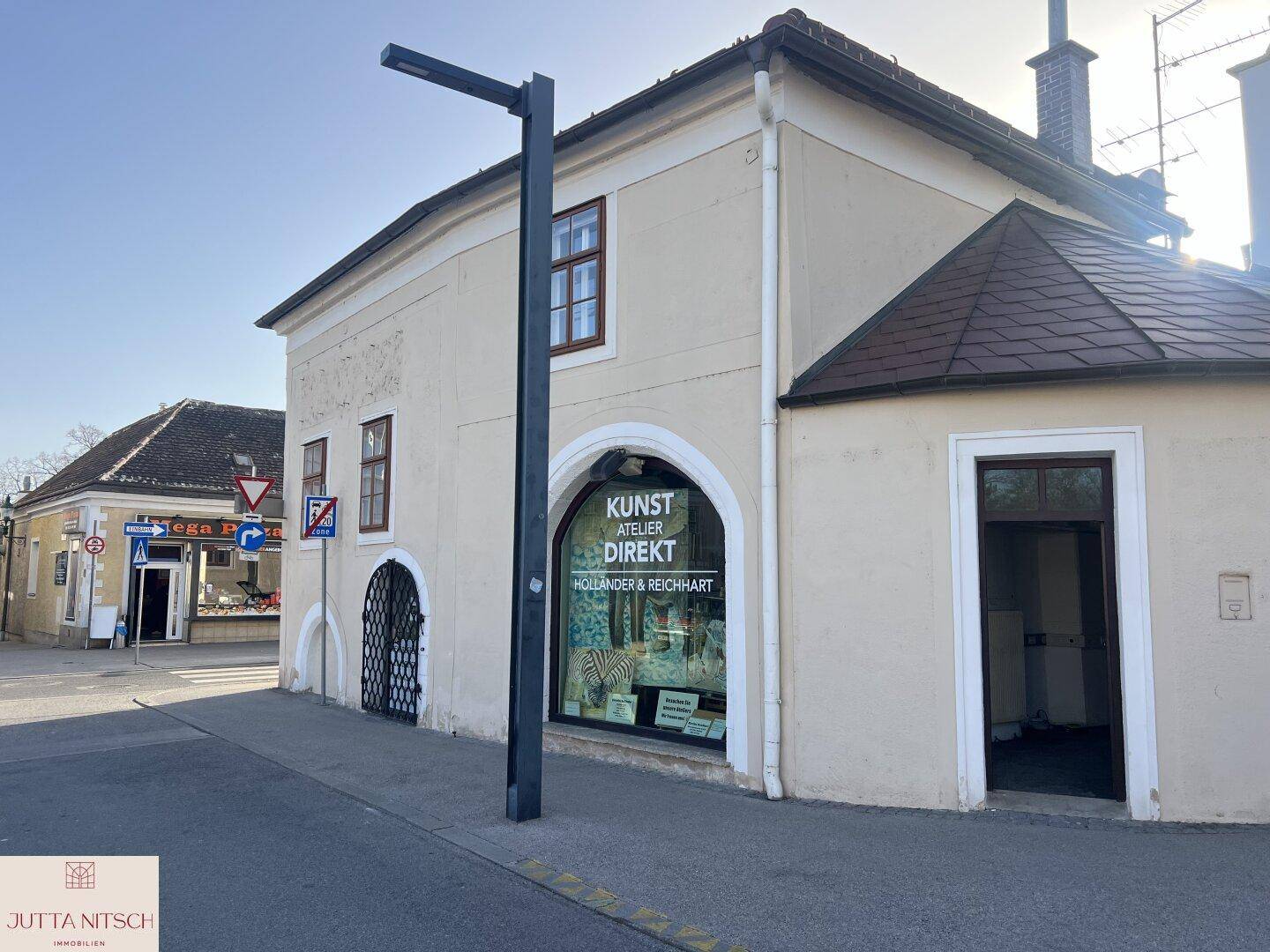 Ansicht des historischen Gebäudes an der Straßenecke mit einem Kunstgeschäft und traditionellen Fenstern.