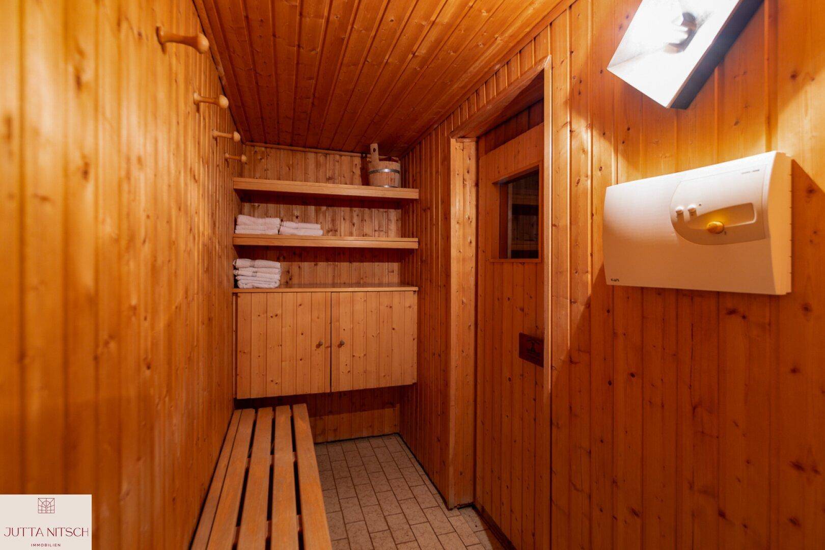 Traditionelle Holzsauna mit Bänken und typischer Ausstattung für Entspannung.