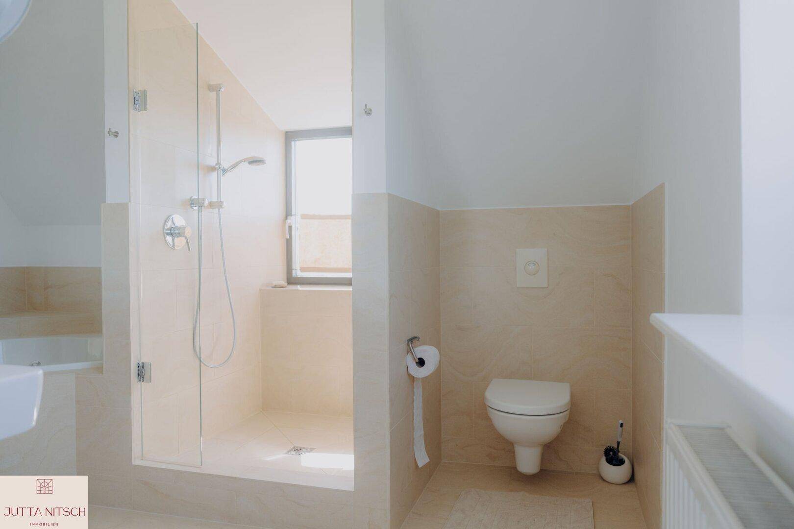 Badezimmer mit begehbarer Dusche, wandhängendem WC und Fenster für Tageslicht.