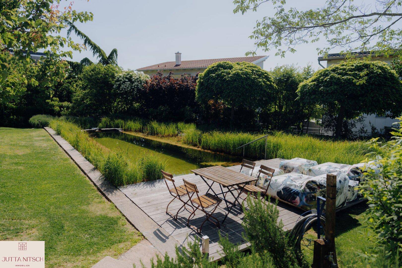 Garten mit Schwimmteich, Holzdeck und Outdoor-Sitzbereich für entspannte Stunden.