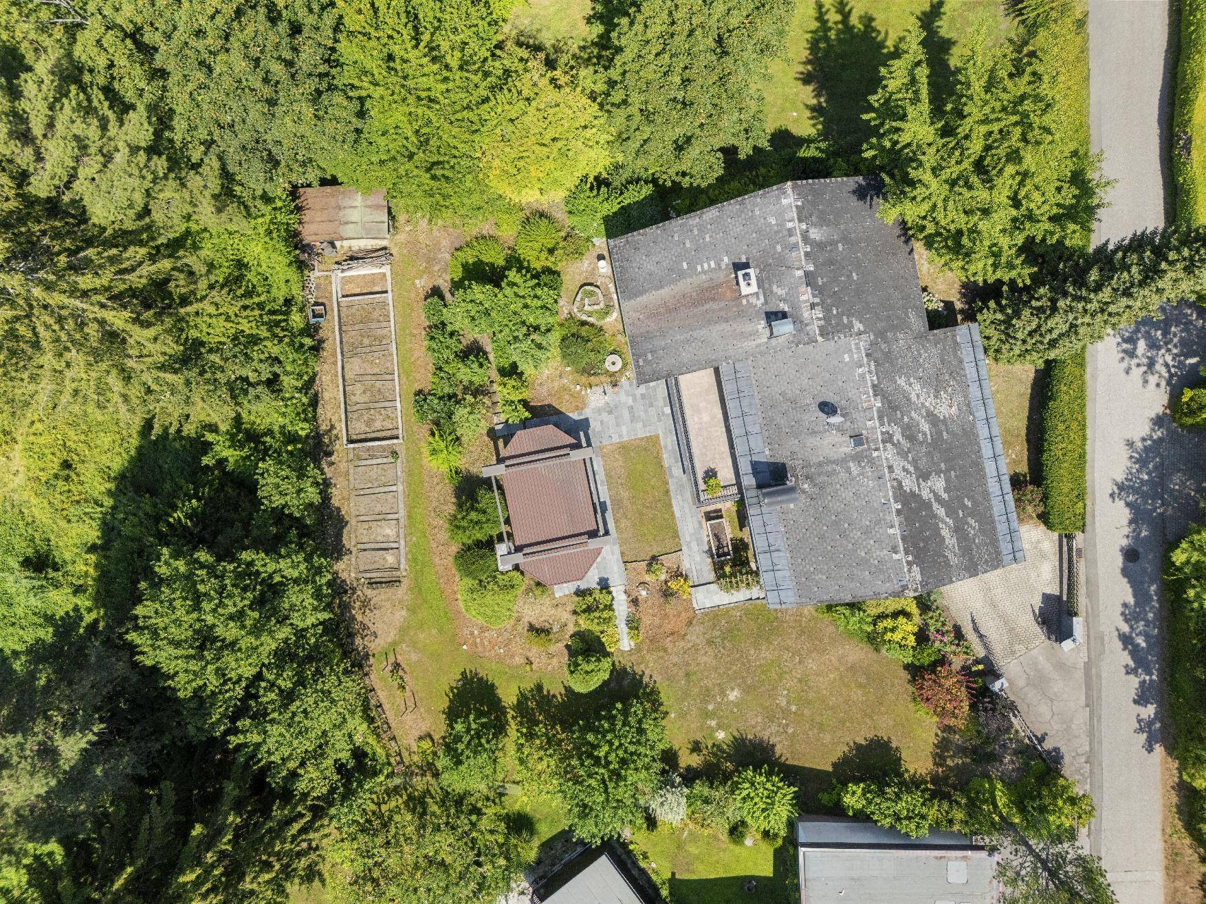 Draufsicht des Anwesens mit großem Garten, Poolbereich und angrenzendem Nutzgarten.
