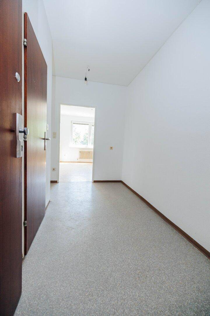 Heller Flur mit Linoleumboden und Eingangstür zu den Wohnräumen.