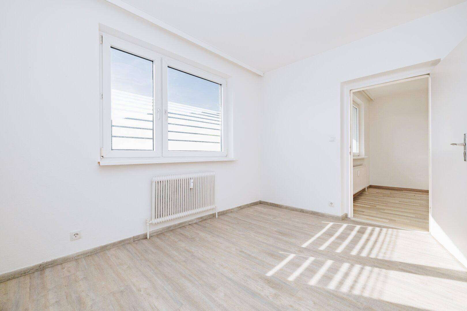 Helles Zimmer mit Laminatboden und Fenster, das viel Tageslicht hereinlässt und renoviert wurde.