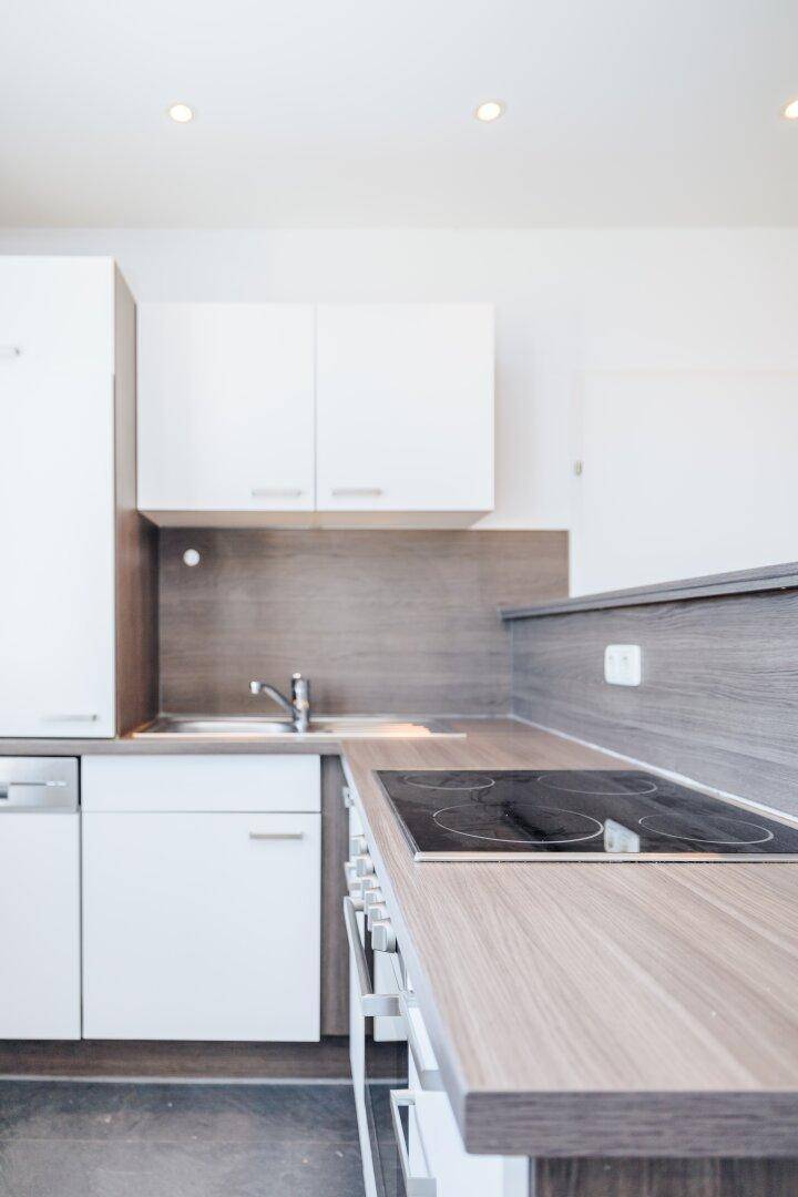 Detailansicht der modernen Küche mit Induktionskochfeld und Holz-Arbeitsplatte.
