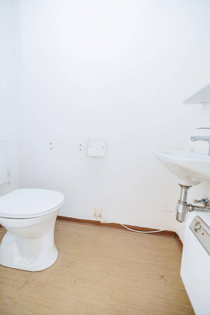 Kleines Gäste-WC mit Toilette und wandhängendem Waschbecken.