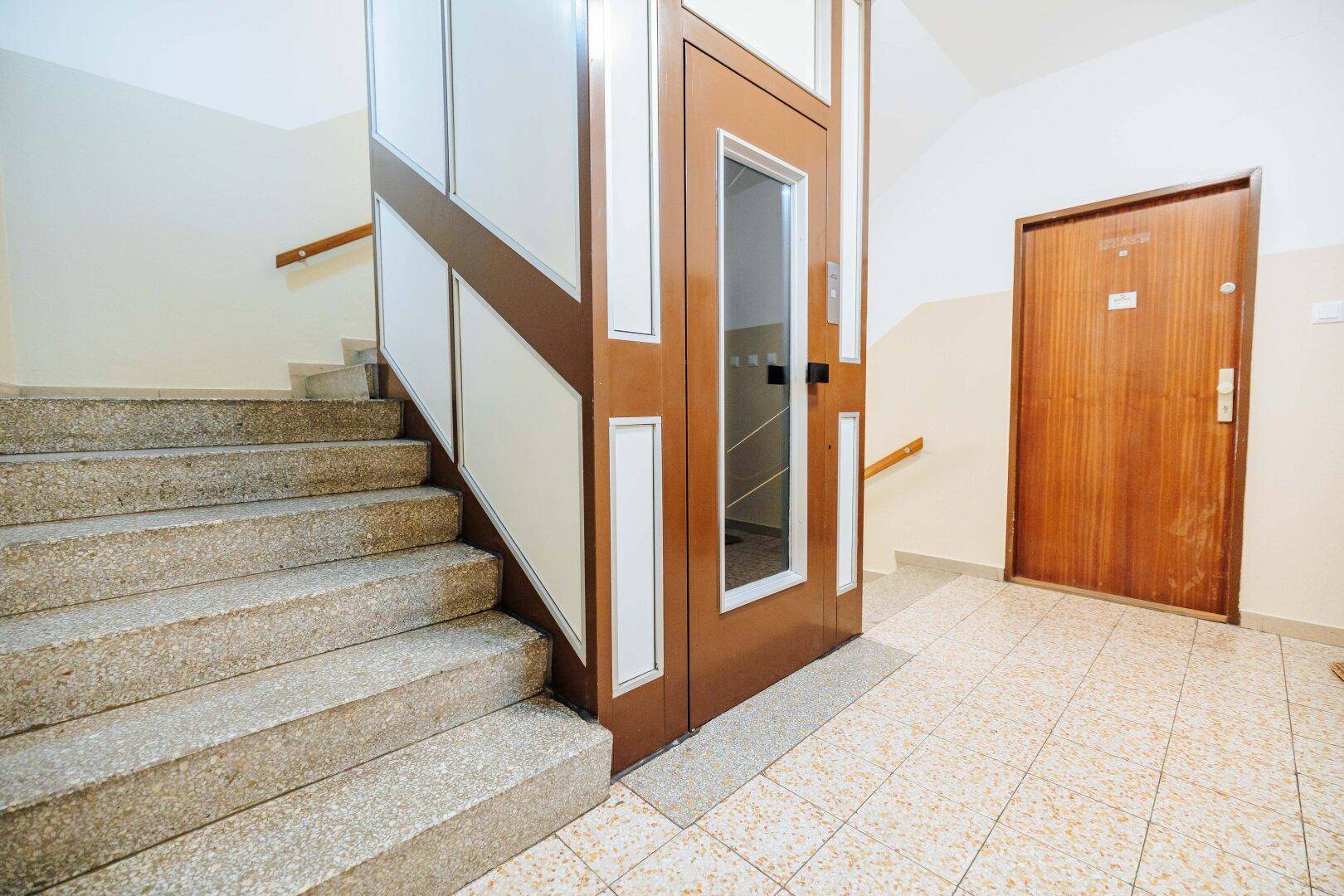 Treppenhaus mit Aufzug und Zugang zu den Wohneinheiten.
