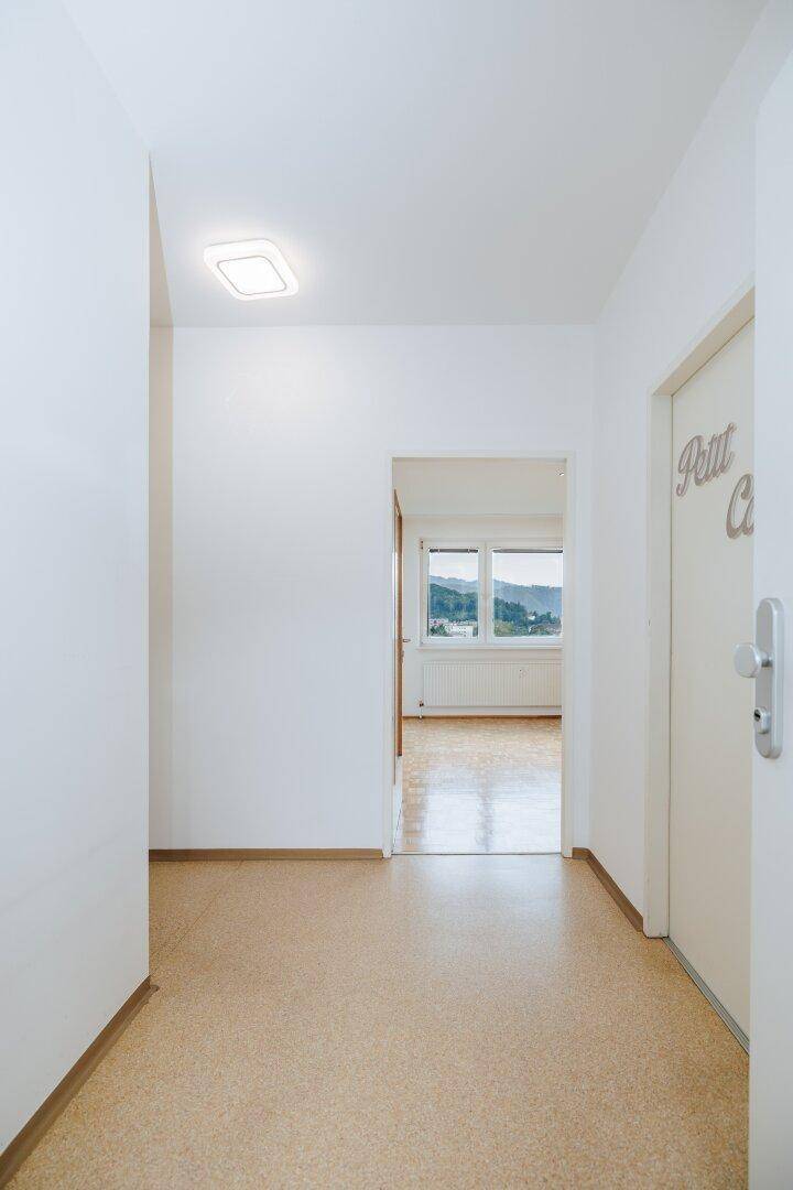 Heller Flur mit Linoleumboden, der zu den weiteren Zimmern der Wohnung führt.
