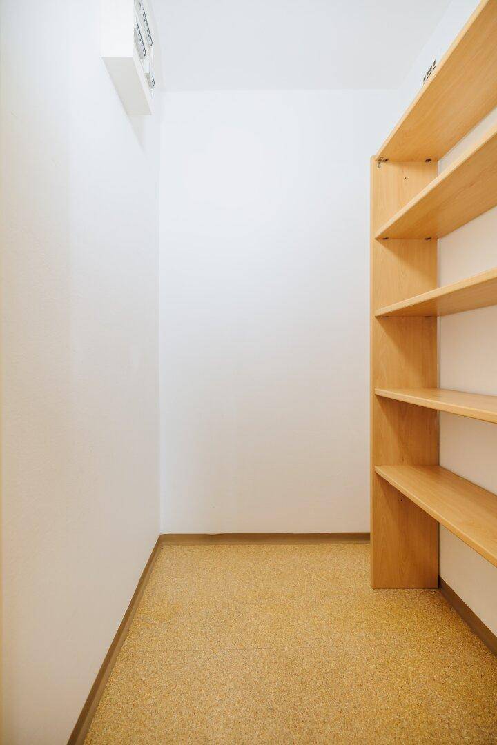 Praktischer Abstellraum mit Holzregalen für zusätzlichen Stauraum.