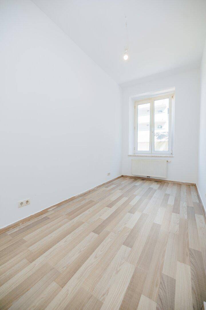 Kleineres, helles Zimmer mit Laminatboden und Fenster, ideal als Schlaf- oder Arbeitszimmer.