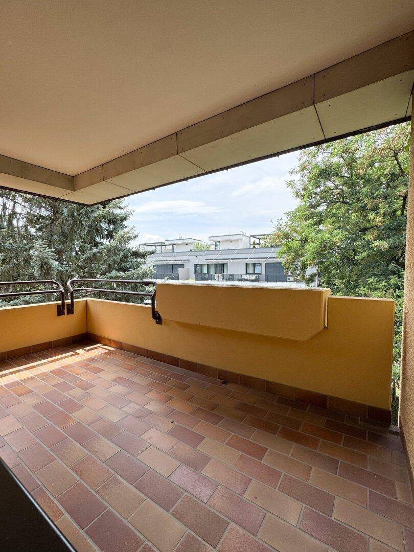 Geräumiger Balkon mit Fliesenboden und Blick ins Grüne, ideal für entspannte Stunden im Freien.