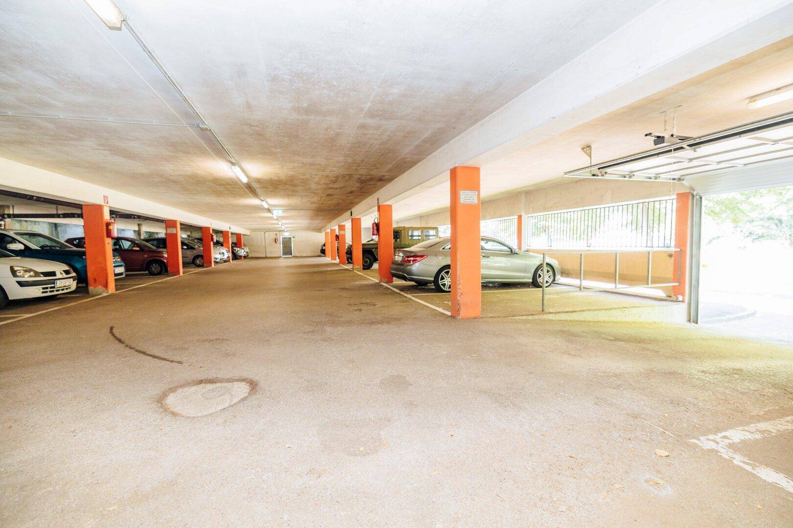 Tiefgarage mit zahlreichen Stellplätzen für Fahrzeuge, gut beleuchtet und zugänglich.