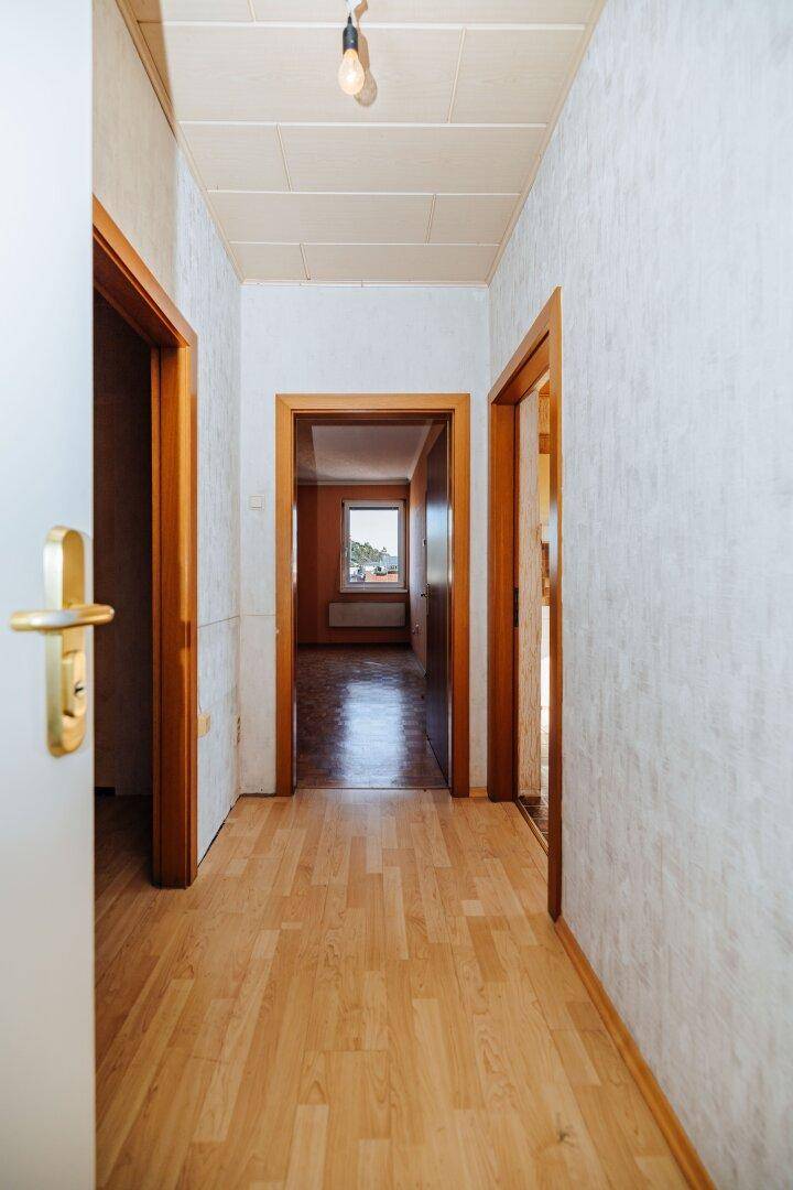 Heller Flur mit Laminatboden und mehreren Türen zu angrenzenden Räumen.