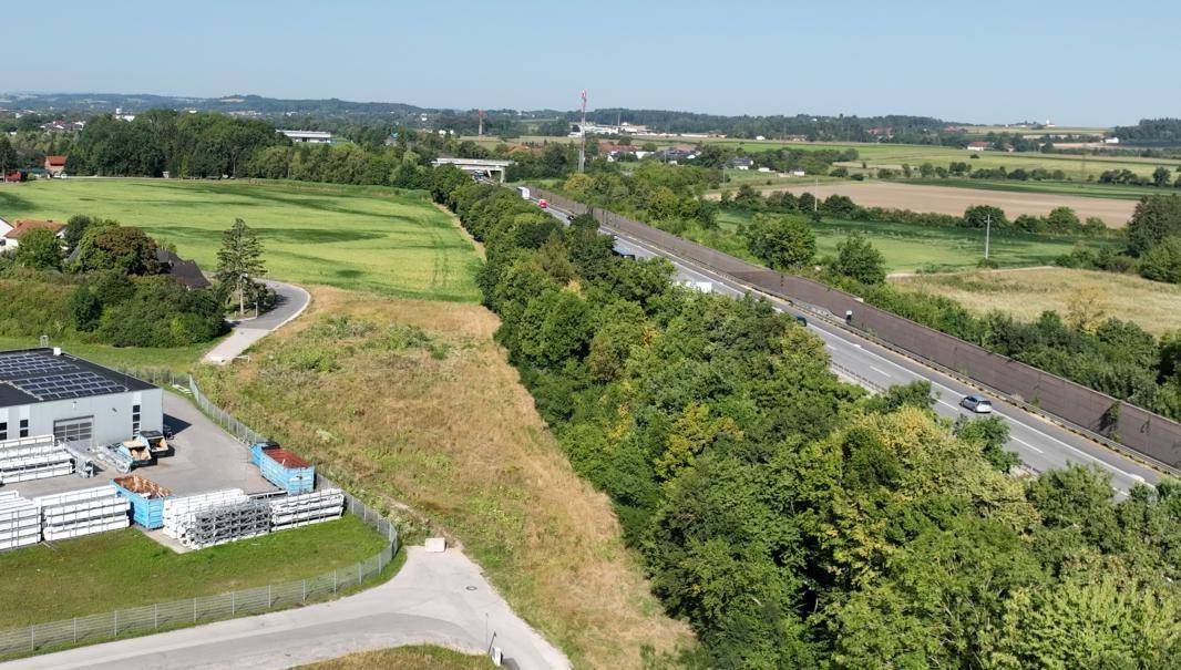 Luftaufnahme eines Gewerbegebäudes und angrenzender Felder neben der Autobahn A25.