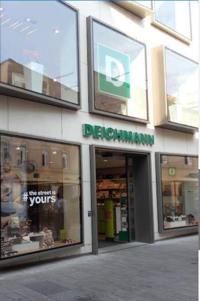 Nahaufnahme des Eingangs und der Schaufenster des Deichmann-Geschäfts mit moderner Architektur.