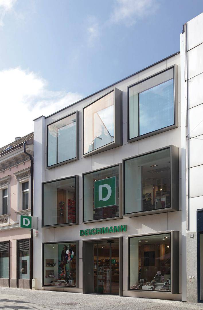 Ansicht der modernen Geschäftsfassade mit großen, quadratischen Schaufenstern und dem Deichmann-Schriftzug.