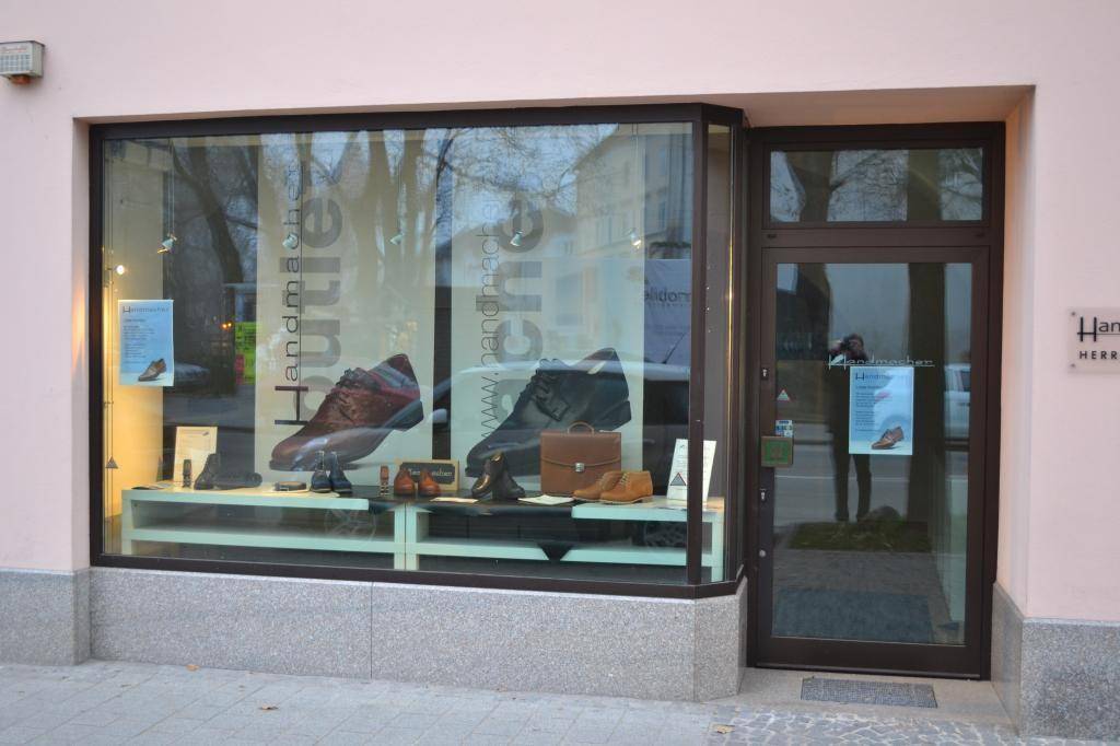 Nahaufnahme des Schaufensters eines Schuhgeschäfts mit verschiedenen Herrenschuhen.