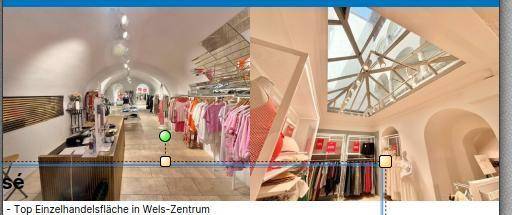 Innenansicht einer modernen Einzelhandelsfläche mit Kleiderständern, Holzboden und einem großen Glasdach.
