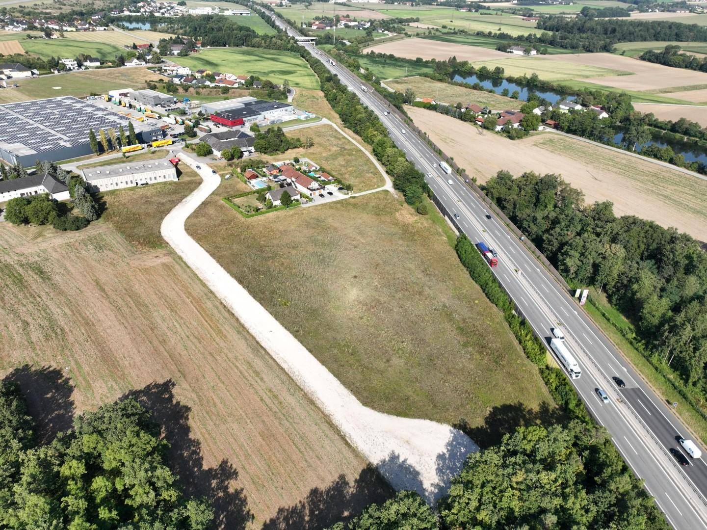 Luftbild eines weitläufigen Gewerbegrundstücks direkt an einer Autobahn gelegen mit Zufahrtsweg.