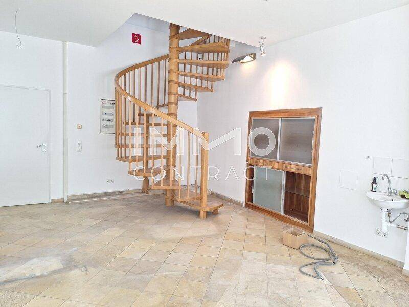 Innenraum mit Holzwendeltreppe, kleiner Spüle und Fliesenboden, bietet Zugang zu einer weiteren Etage.